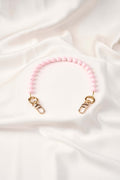strap celular artesanal Blush Moment en color rosa con broches de oro, elaborado a mano por artesanas colombianas.