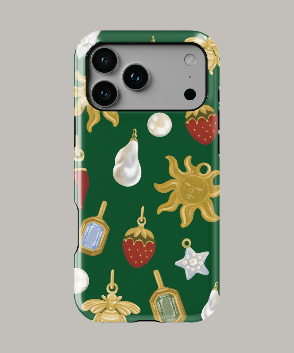 Funda personalizada para iPhone con diseño colorido de amuletos y frutas sobre fondo verde.