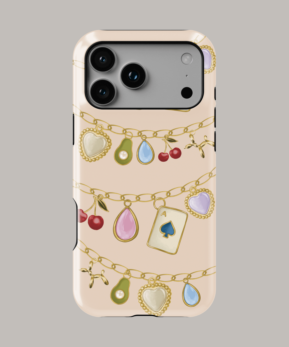 Funda personalizada iPhone resistente con diseño de joyas y charms coloridos sobre fondo nude.