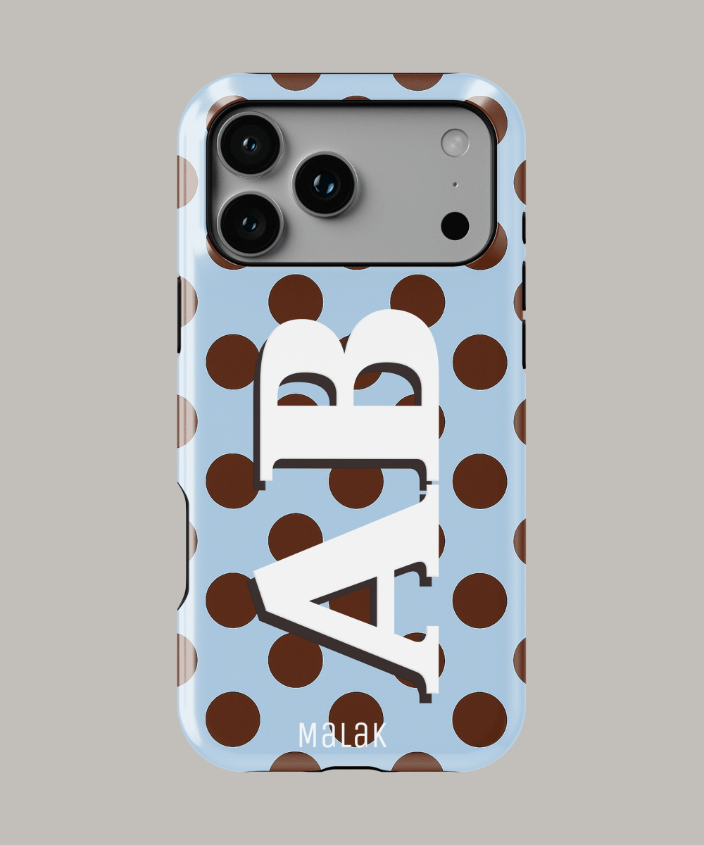 Funda personalizada para iPhone 15 con diseño de letras y puntos marrones sobre fondo azul.