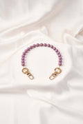 strap celular Purple Flow, lujo artesanal colombiano con perlas y broches dorados, tejido a mano para mayor seguridad.