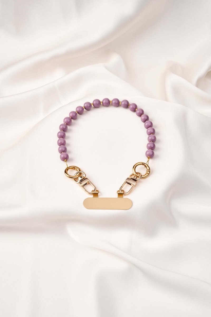 strap celular Purple Flow elaborado a mano con perlas moradas y broches de acero para mayor comodidad y seguridad.