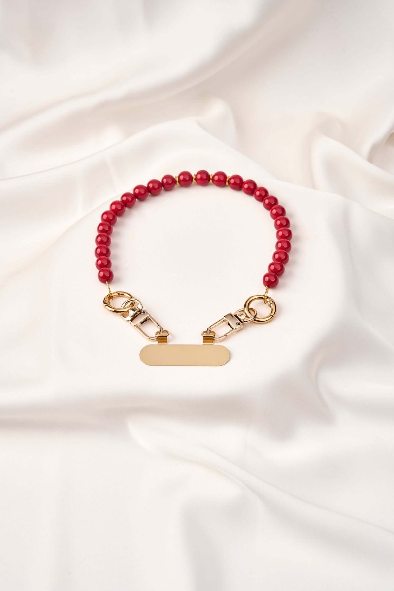strap celular artesanal Red Signal con perlas rojas y broches dorados, diseñado por MALAK.