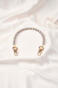 strap celular artesanal Silver Calm tejido a mano con perlas y broches de acero en fondo blanco.