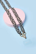 strap de leopardo negro artesanal con broches dorados sobre fondo azul