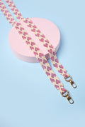 Strap de lujo rosa con diseño de corazones en mostacilla, elaborado a mano por artesanas colombianas.