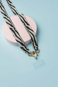 strap de lujo zebra en detalles de mostacilla con broches dorados sobre fondo azul, artesanía colombiana.