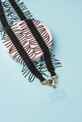 strap de lujo flecos negro, elaborado con cristales de mostacilla y broches dorados, mostrando diseño artesanal único.