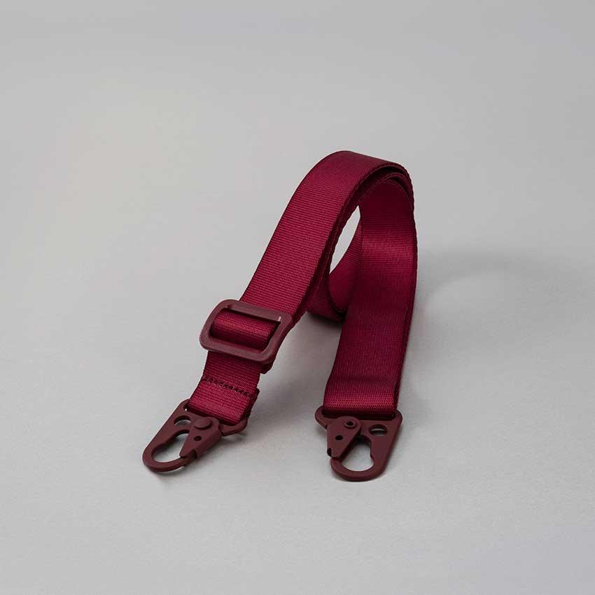 Correa ajustable para funda color vino, fabricada en naylon suave, longitud de 2 mts, con adaptador universal.